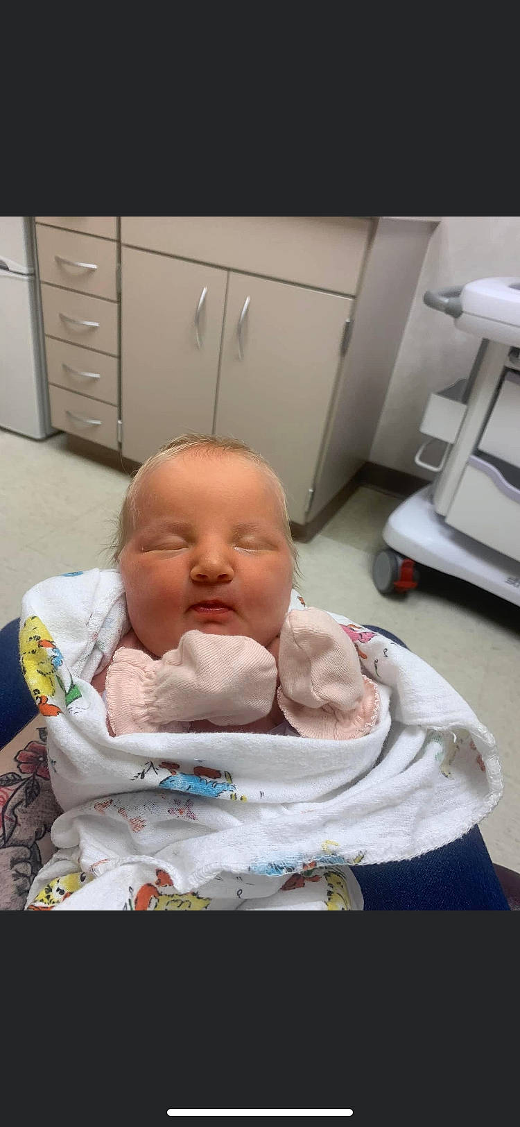 June is registered to the contest to win money with this photo: baby, baby_products, baby_toddler_clothing, cabinetry, cheek, chest_of_drawers, child, comfort, cupboard, drawer, dresser, event, health_care, hospital_bed, person, room, service, sitting, thumb, toddler