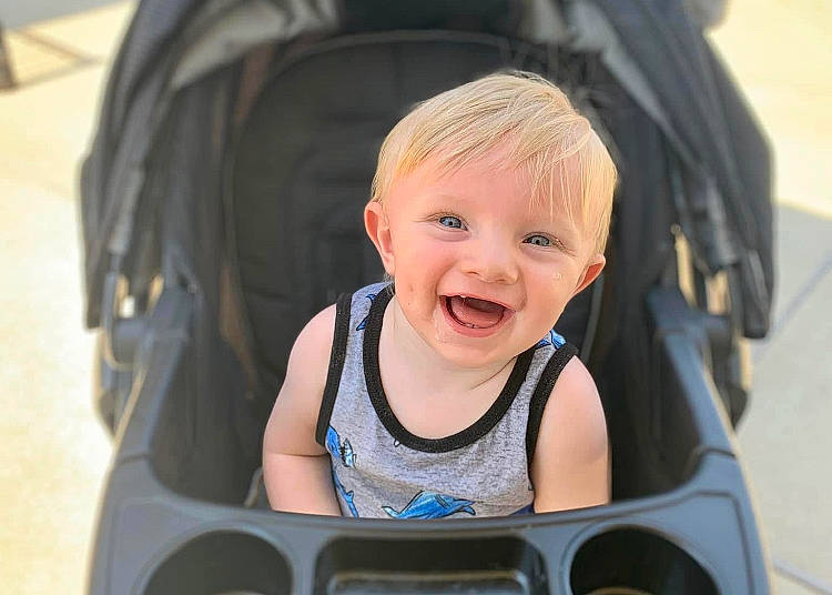 Jasper is registered to the contest to win money with this photo: auto_part, baby, baby_carriage, baby_products, baby_toddler_clothing, black, cheek, child, eyelash, face, facial_expression, fun, hairstyle, happy, iris, joy, leisure, person, product, sitting