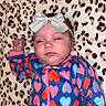 Ariella is registered to the contest to win money with this photo: baby, sleeping, headband, bow, onesie, heart_pattern, colorful_clothing, blanket, leopard_print, infant, peaceful, cozy, child, face, cute, pink, blue, soft_texture, resting, portrait