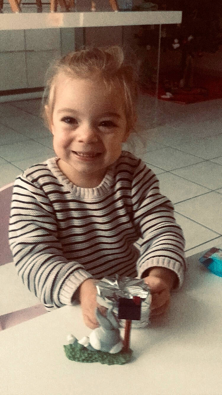 Nina participe au concours pour gagner de l'argent avec cette photo : cheek, child, cool, eye, flooring, fun, happy, human, iris, joy, nail, pattern, person, play, sitting, sleeve, smile, t_shirt, table, toddler