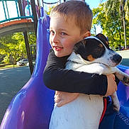 Burger joined the competition — help win amazing prizes! child, dog, hugging, slide, playground, outdoor, sunny, trees, blue_sky, smiling, animal, pet, boy, leash, park, daytime, happy, casual_clothing, fun, nature