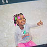 Teighan joined the competition — help win amazing prizes! child, colorful_hair_beads, cute, expression, fashion, hairstyle, happy, indoor, joyful, long_sleeve_shirt, person, pink_pants, playful, pointing, portrait, rainbow_heart, sitting, skin_tone, smiling, young_child
