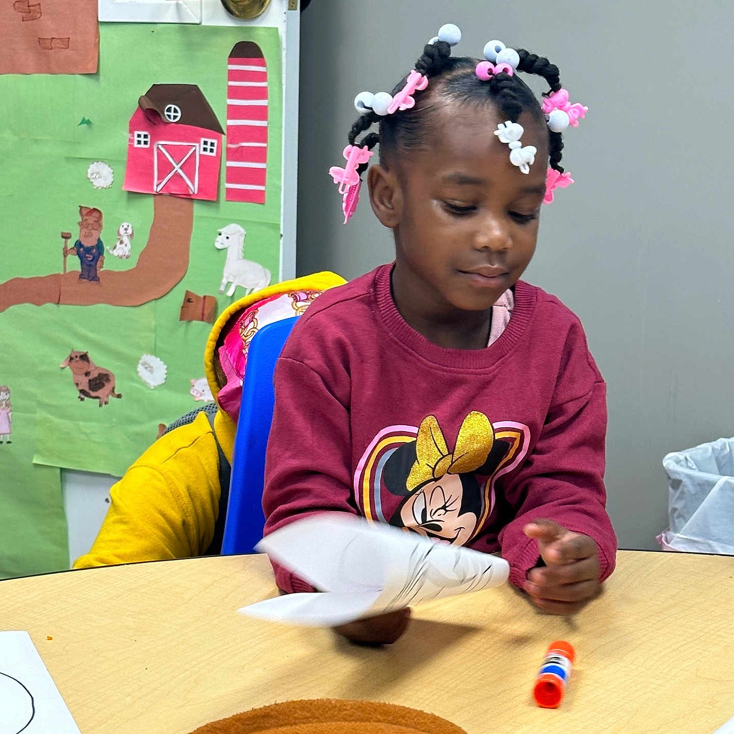 Teighan joined the competition — help win amazing prizes! barn, chair, child, classroom, colorful, cowboy_hat, crafting, decorations, farm_animals, girl, glue_stick, hair_accessories, indoor, minnie_mouse, paper_craft, seated, sweatshirt, table, wall_art, young_child