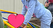 Teighan is registered to the contest to win money with this photo: active, blue_clothing, casual_clothing, child, climbing, cloudy_sky, colorful, daytime, fence, fun, girl, grass, hair_bows, outdoor, park, person, pink_bow, play_structure, playground, young_child