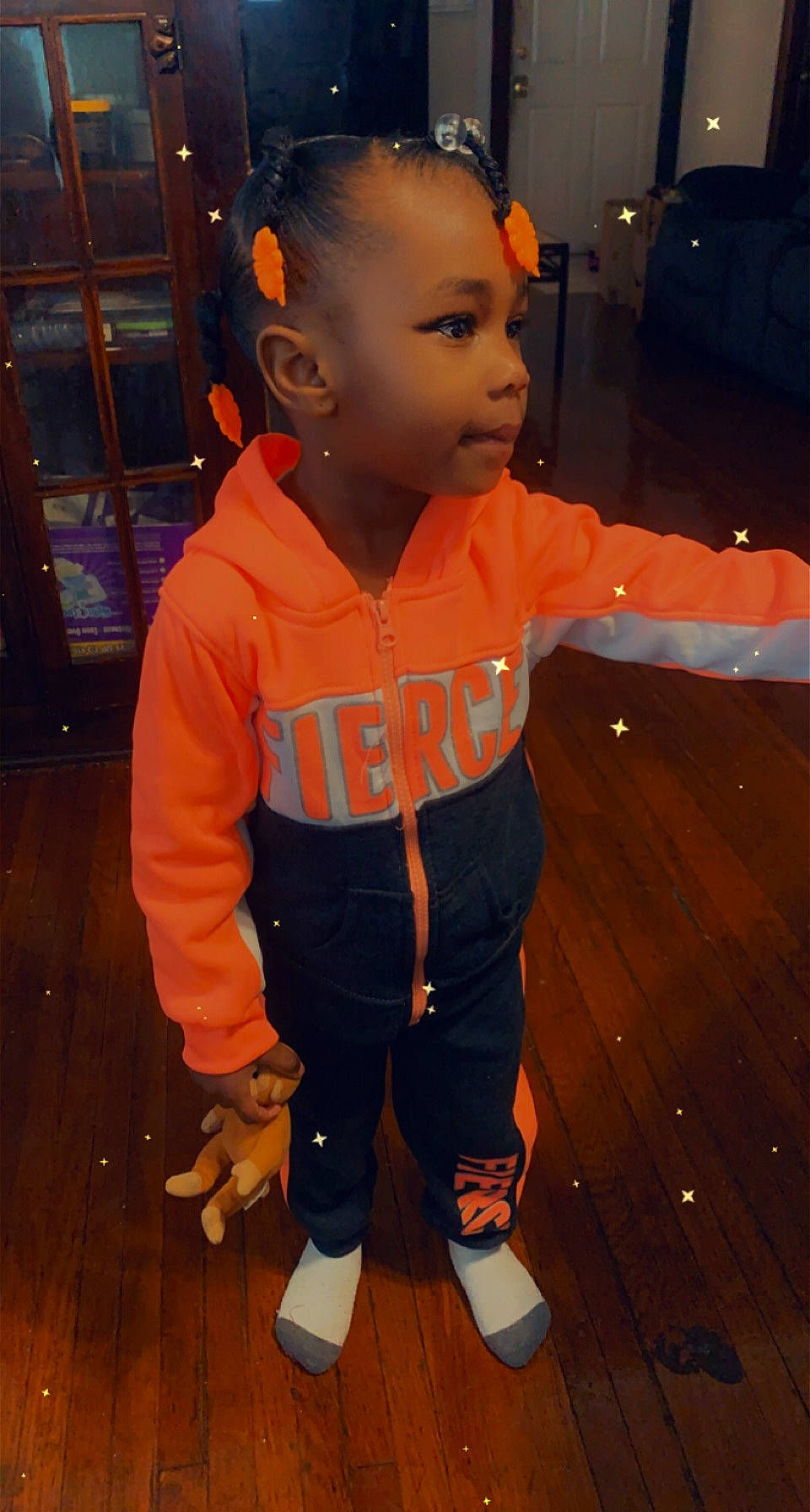 Teighan is registered to the contest to win money with this photo: baby_toddler_clothing, cheek, chin, eye, face, finger, floor, flooring, fun, happy, hardwood, head, nose, orange, person, skin, sleeve, standing, thumb, toddler