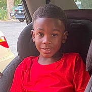 Tesean is registered to the contest to win money with this photo: boy, car_interior, car_seat, casual, child, daylight, face, haircut, happy, indoors, parking_lot, people, portrait, red_shirt, seatbelt, sitting, smiling, vehicle, window, young