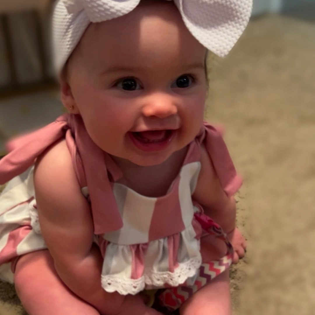 Hartleigh joined the competition — help win amazing prizes! accessories, baby, babylaughing, bonnet, cap, clothing, dress, face, formalwear, happy, hat, head, jewelry, laughing, necklace, person, photography, portrait, sitting, smile