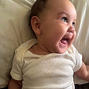Jaelynn joined the competition — help win amazing prizes! baby, bed, cheeks, cheerful, child, cute, expression, eyes, face, happy, head, human, infant, lying_down, mouth_open, person, pillow, skin, smiling, white_onesie