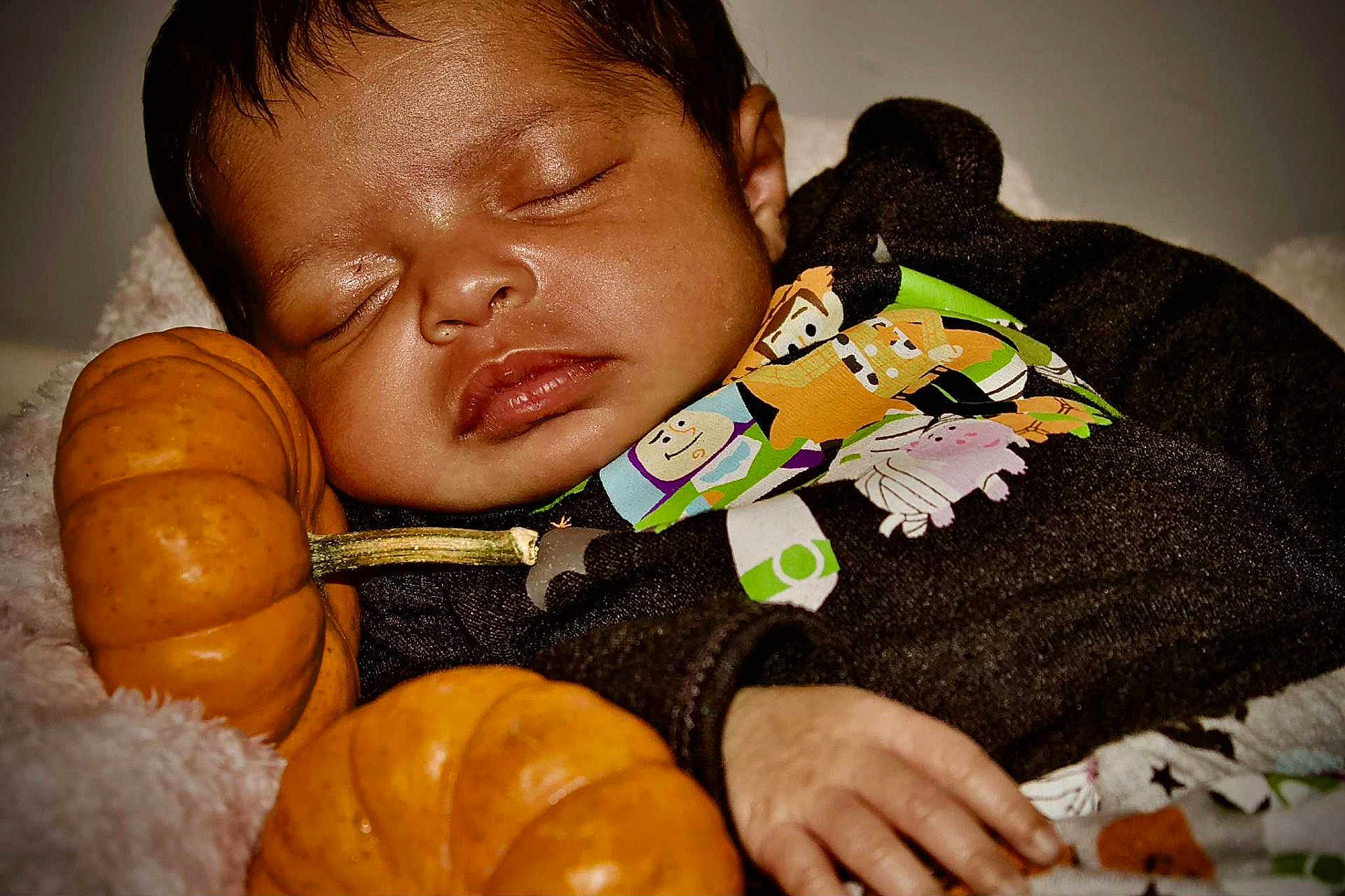Areliana is registered to the contest to win money with this photo: baby, sleeping, pumpkin, hand, clothing, cartoon, black_outfit, cute, cozy, autumn, child, face, peaceful, soft_blanket, closeup, infant, portrait, relaxing, young, indoors