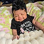 baby, smiling, black_headband, flower_headband, onesie, blanket, fluffy_blanket, pastel_blanket, infant, cute, sleepy, happy, indoors, child, lying_down, clothing, hand, face, head, toddler