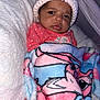 Areliana is registered to the contest to win money with this photo: baby, infant, blanket, hat, knit_hat, pink_clothing, polka_dot, face, expression, indoor, soft_texture, cozy, cartoon_character, wrapped, child, portrait, newborn, cute, warm, person