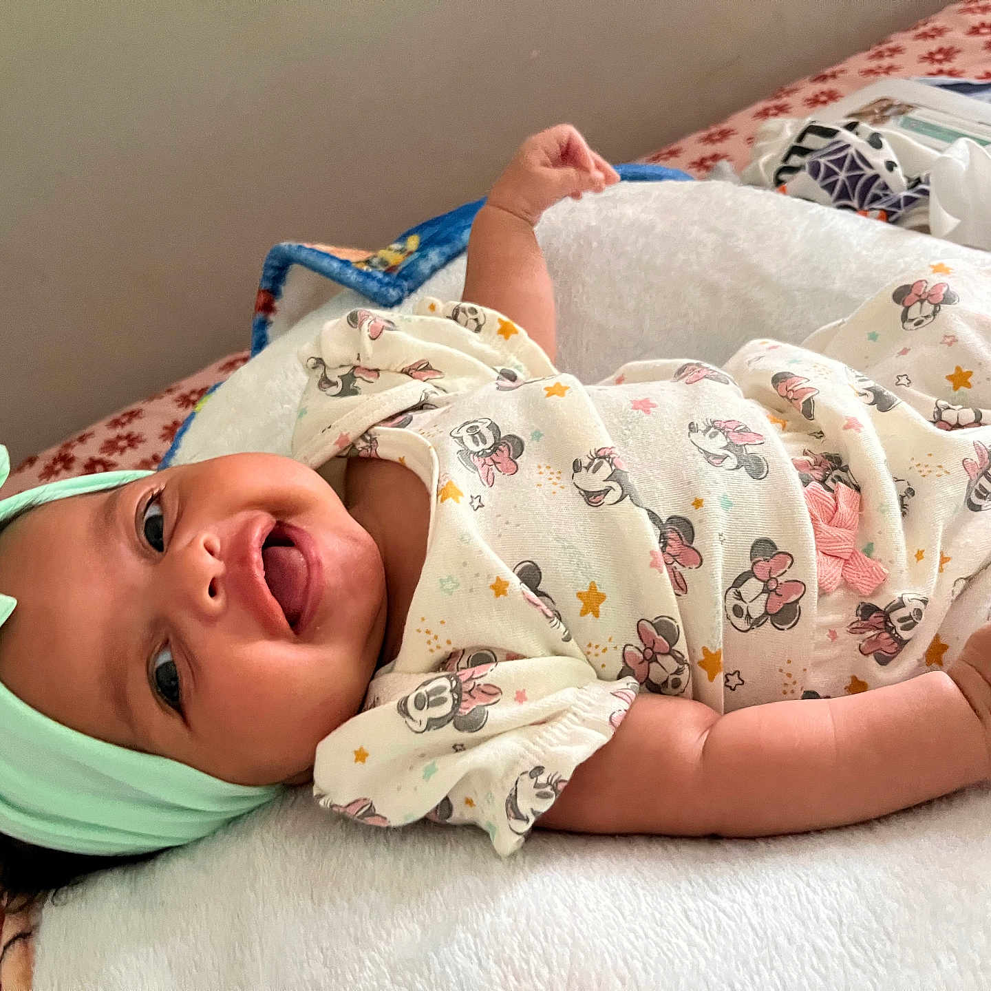 Areliana joined the competition — help win amazing prizes! adorable, baby, bed, blanket, bow, child, cute, happy, headband, indoor, infant, lying_down, minnie_mouse, onesie, patterned_clothing, person, playful, smiling, soft_texture, tongue_out