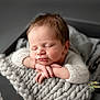 Alfie is registered to the contest to win money with this photo: newborn, baby, sleeping, knit_blanket, cozy, infant, portrait, soft_light, peaceful, cute, hands, closeup, resting, child, studio, warm, face, tiny_fingers, relaxation, gray_background