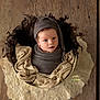 baby, newborn, infant, wrapped, hat, basket, blanket, knitted, wood_floor, cozy, portrait, indoors, cute, soft_texture, child, sleeping_baby, headwear, flooring, warm, studio_photo