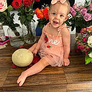 Ariella is registered to the contest to win money with this photo: baby, toddler, child, pink_bow, headband, pink_dress, tulle, smile, sitting, wooden_table, roses, bouquet, vase, glass_jar, cantaloupe, flower_petals, home_interior, television, happy, portrait