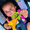toddler, child, flower, car_seat, safety_strap, smile, happy, cute, curious, outdoor, bright_colors, yellow_flower, baby, portrait, face, young_child, holding, nature, close_up, playful
