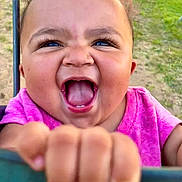 Amaia joined the competition — help win amazing prizes! baby, child, outdoor, swing, playground, grass, happy, smiling, blue_eyes, pink_shirt, hand, face, person, joyful, fun, summer, nature, blurred_background, excited, close_up