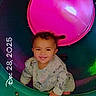 child, toddler, playground, smile, happy, colorful, plastic_tunnel, pink, green, clothing, curly_hair, hands, face, portrait, indoor, play, cute, young_child, fun, baby