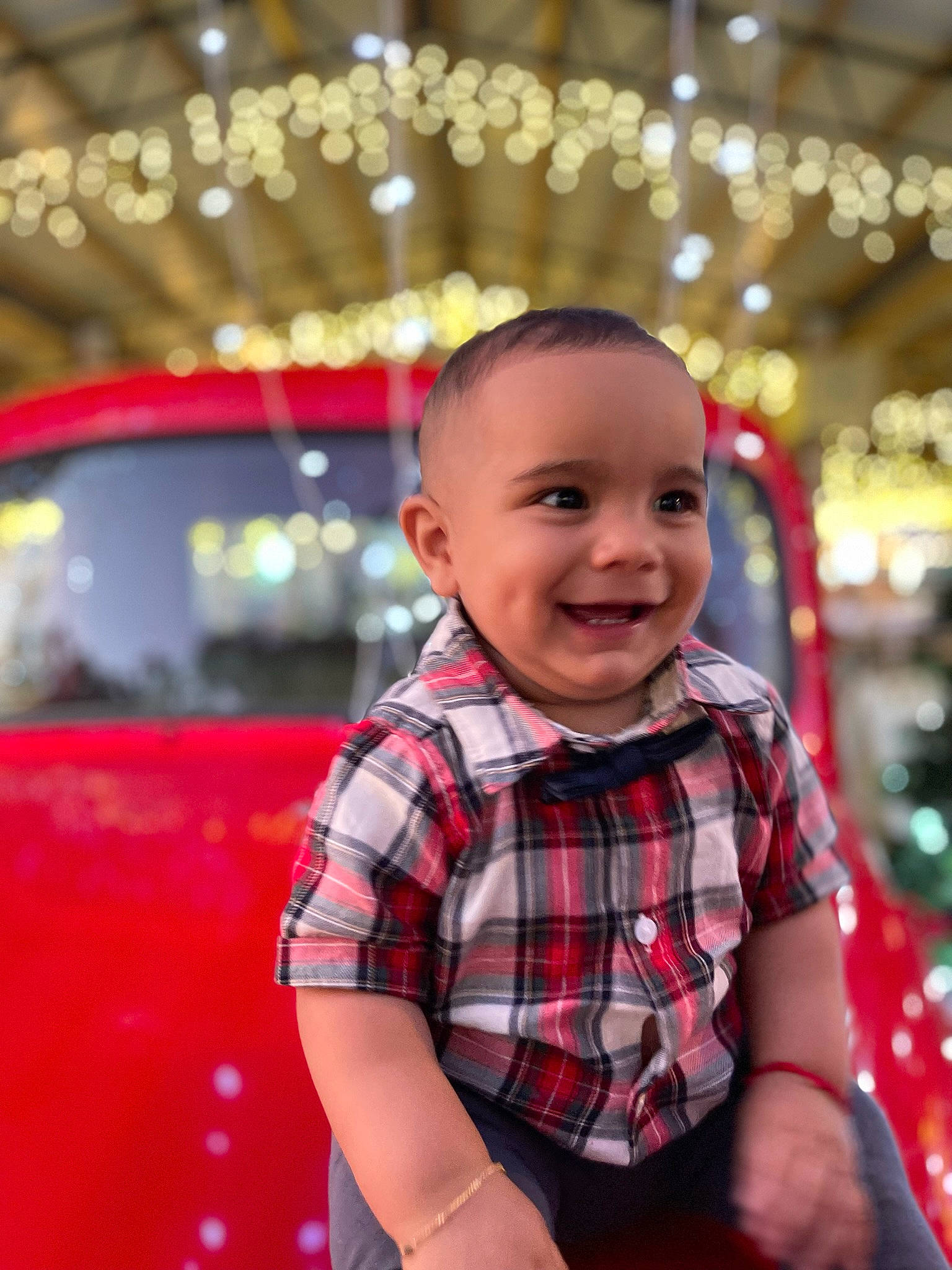 Sebastian is registered to the contest to win money with this photo: automotive_lighting, baby, child, city, event, flash_photography, fun, happy, joy, leisure, magenta, motor_vehicle, pattern, person, plaid, recreation, sitting, smile, standing, t_shirt