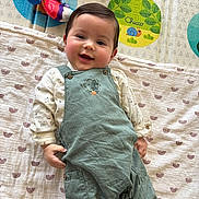 Telio a rejoint le concours — aidez-le/la à gagner de superbes lots ! baby, blanket, child, clothing, colorful, cute, face, happy, indoor, infant, lying_down, overalls, pattern, person, playmat, portrait, smile, soft_toys, toy, young_child