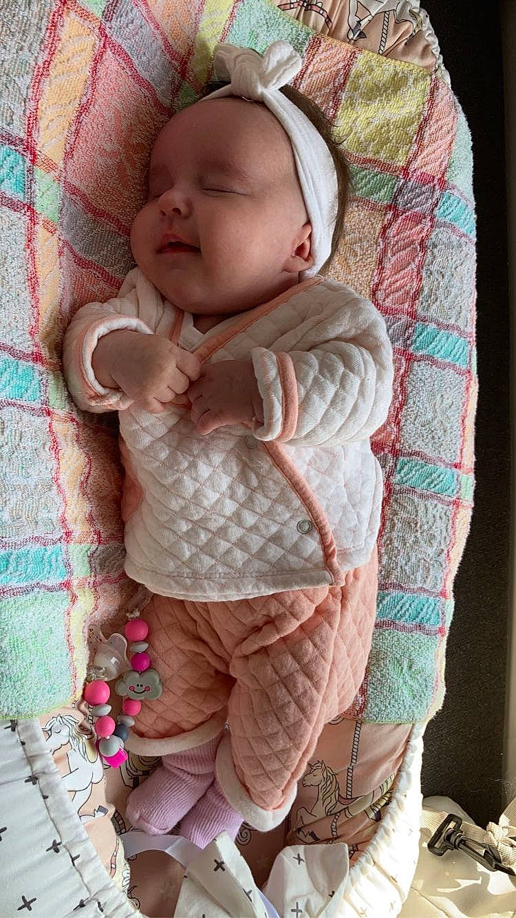 Noëlya a rejoint le concours — aidez-le/la à gagner de superbes lots ! baby, baby_toddler_clothing, cheek, child, comfort, eye, face, head, linens, magenta, outerwear, pattern, person, pink, skin, sleeve, textile, toddler, wood, wool