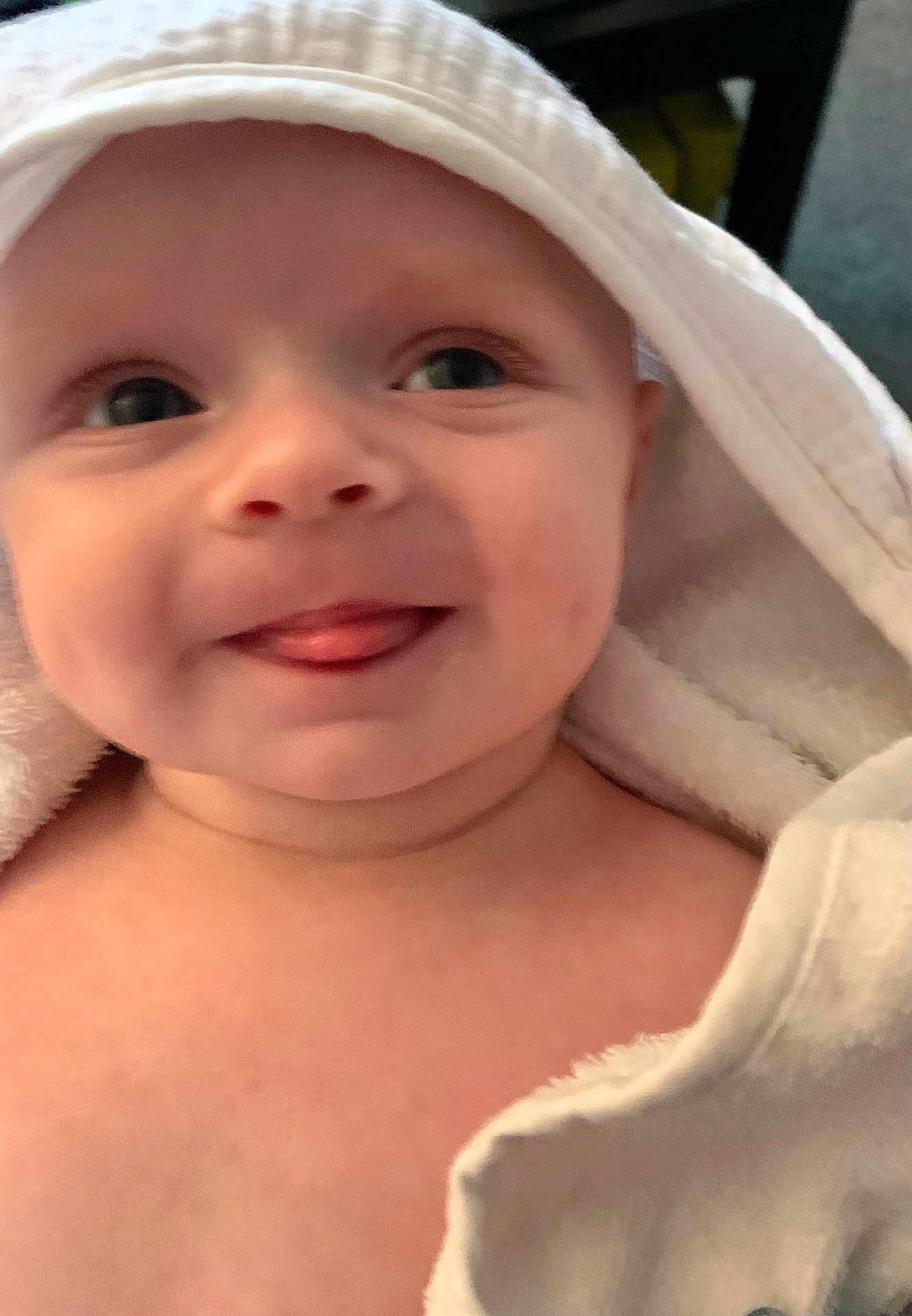 Vinnie is registered to the contest to win money with this photo: baby, towel, hood, face, tongue, skin, expression, cute, child, infant, playful, soft, white, closeup, portrait, smiling, indoors, person, newborn, happy