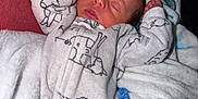 Giovanni is registered to the contest to win money with this photo: baby, newborn, sleeping, blanket, onesie, animal_print, cozy, soft, infant, cute, peaceful, resting, fabric, bed, comfort, child, portrait, indoors, warm, sleep