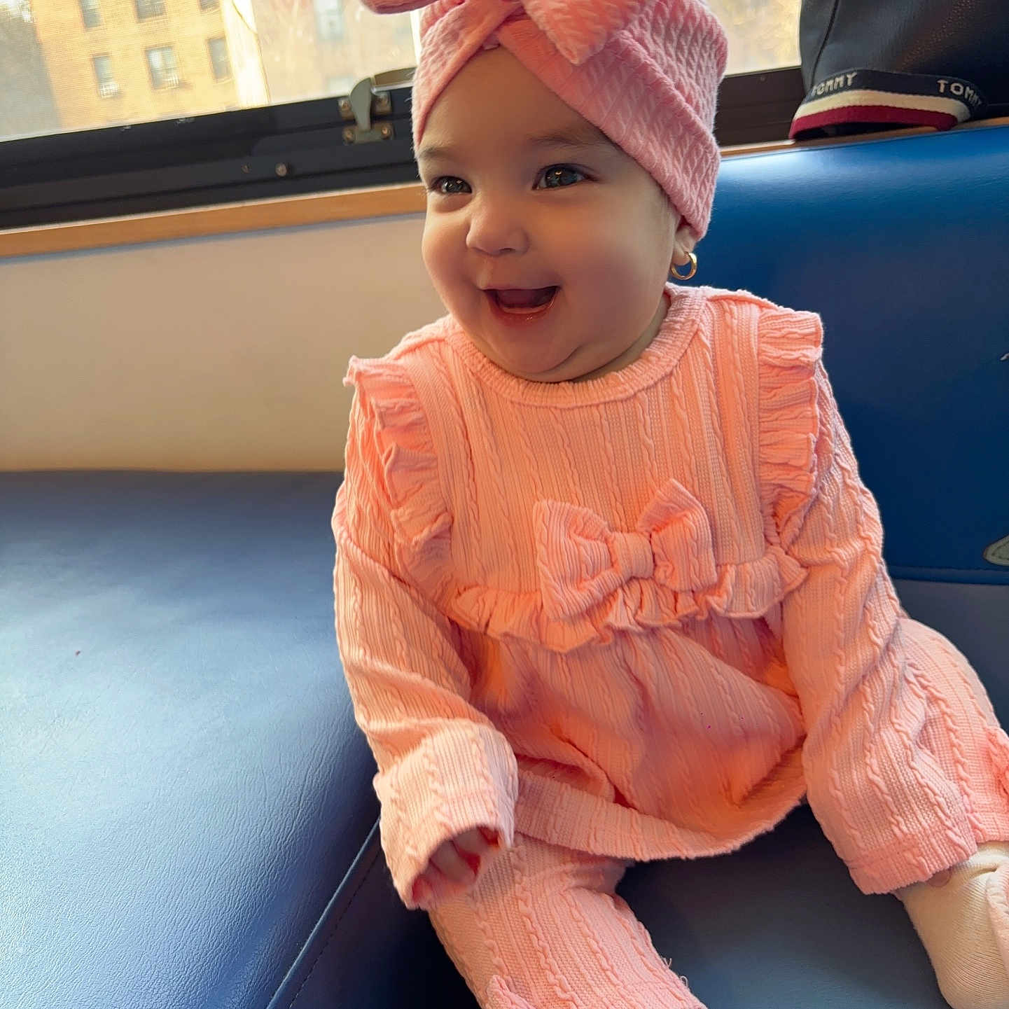 Mia Dayance joined the competition — help win amazing prizes! baby, bow, child, couch, cozy, cute, earrings, fashion, happy, headwrap, indoor, infant, knitwear, pink_outfit, portrait, sitting, smiling, soft_lighting, sunlight, window