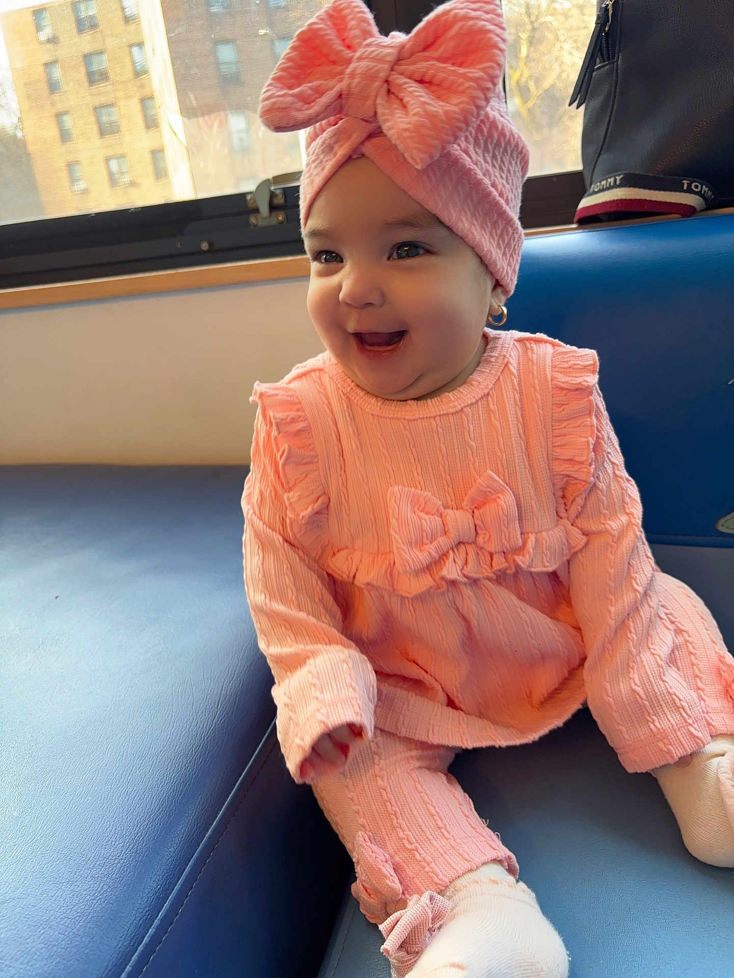 Mia Dayance joined the competition — help win amazing prizes! baby, pink_outfit, headwrap, bow, smiling, sitting, couch, window, sunlight, earrings, indoor, child, happy, knitwear, cute, portrait, infant, fashion, cozy, soft_lighting