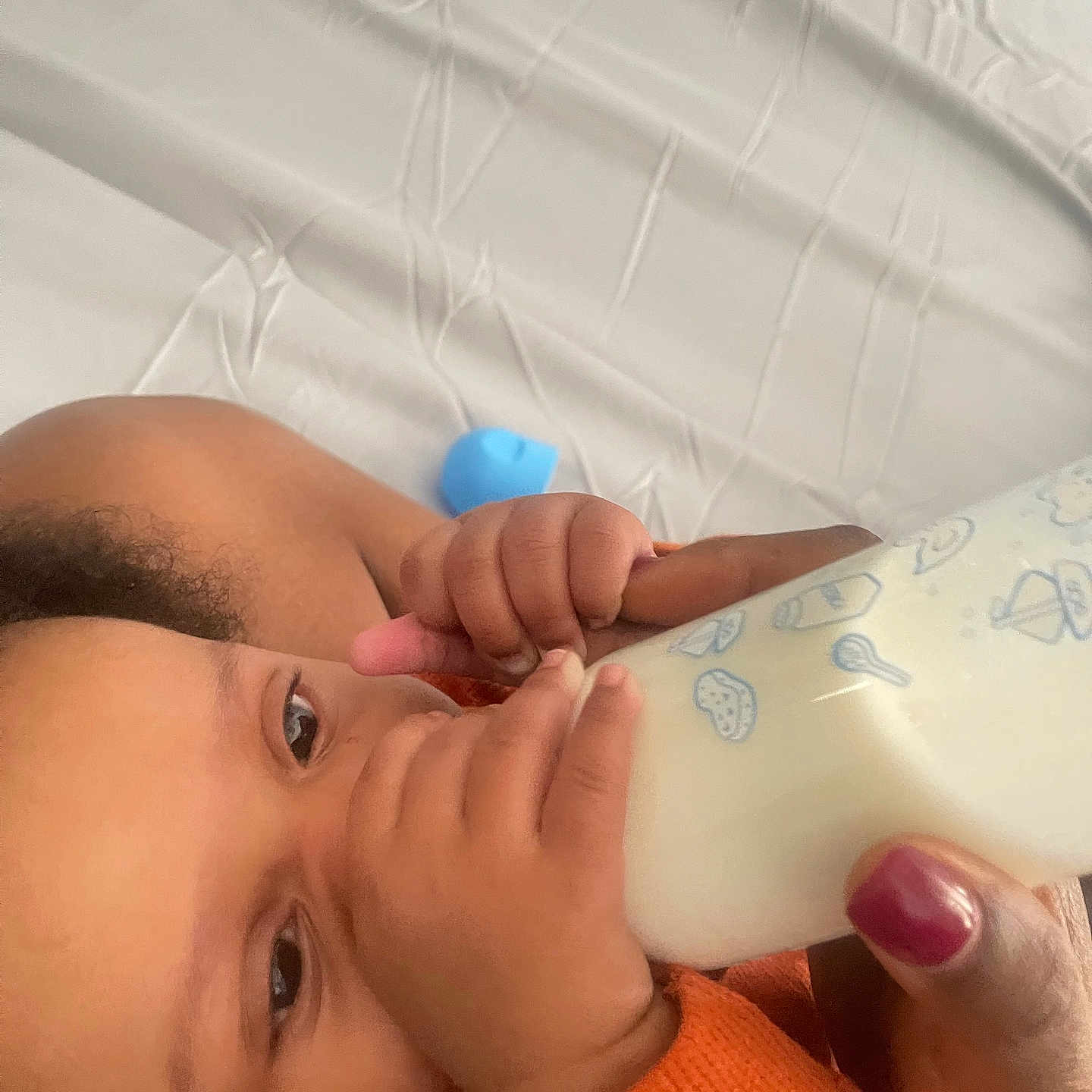 Leopold is registered to the contest to win money with this photo: baby, bed, bottle, care, close_up, comfort, eyes, face, feeding, feeding_time, hand, infant, milk, nail_polish, orange_clothing, person, sheet, skin, toddler, wrinkles