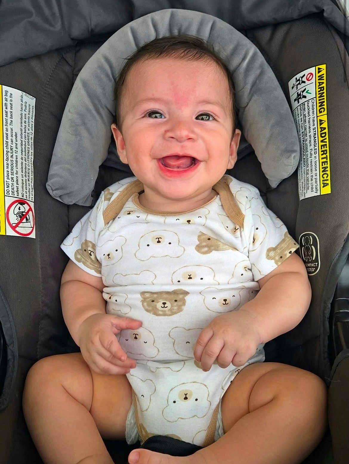 Martin is registered to the contest to win money with this photo: baby, smiling, car_seat, onesie, infant, child, cute, happy, face, hands, legs, seatbelt, pattern, bear, clothing, indoors, person, baby_clothes, sitting, young_child