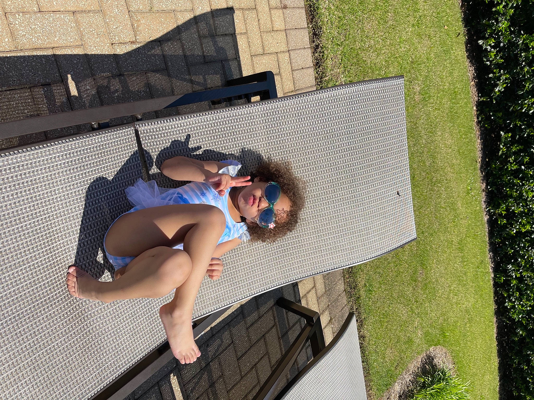 Marisol is registered to the contest to win money with this photo: bag, comfort, eyewear, flooring, foot, fun, grass, human_leg, knee, leisure, luggage_and_bags, outdoor_furniture, pattern, people_in_nature, person, recreation, shorts, sitting, street_fashion, sunglasses