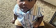 Kevion joined the competition — help win amazing prizes! baby, child, hat, striped_shirt, drool, carpet, floor, indoor, person, cute, sitting, clothing, foot, hand, home, casual, infant, portrait, curious, young