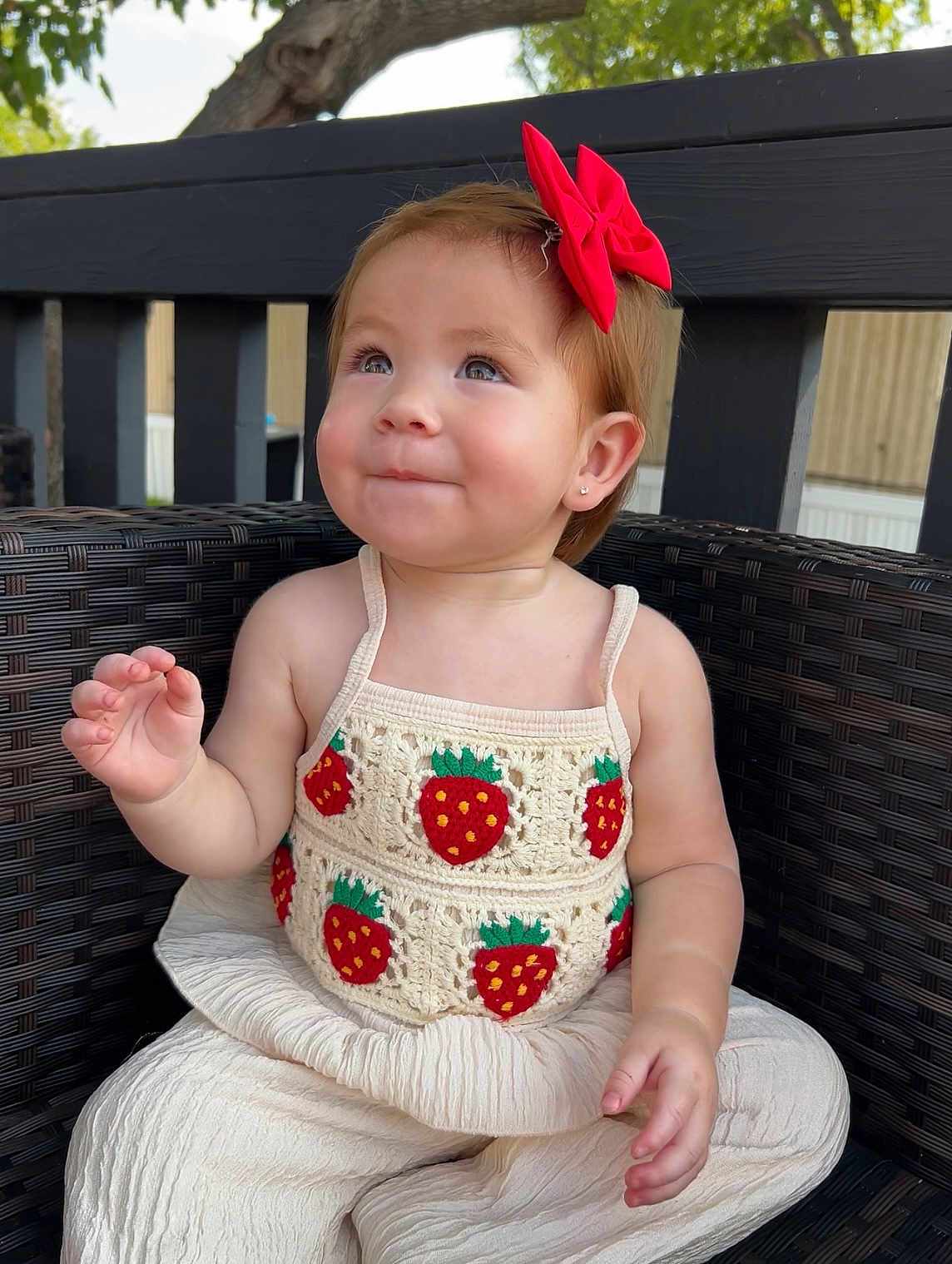 Jaylene is registered to the contest to win money with this photo: toddler, child, smile, red_bow, strawberry_pattern, crochet_top, white_pants, wicker_chair, outdoor, tree, wooden_fence, cute, portrait, baby, sitting, happy, earrings, short_hair, natural_light, casual_clothing
