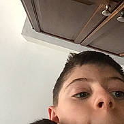 Fluffy is registered to the contest to win money with this photo: child, boy, face, selfie, indoor, ceiling, cabinet, wood, hair, skin, nose, ear, eye, portrait, casual, young, closeup, expression, background, lighting