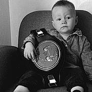 Tao a rejoint le concours — aidez-le/la à gagner de superbes lots ! toddler, child, denim_jacket, championship_belt, couch, indoor, portrait, serious, sitting, face, expression, clothing, furniture, young_child, person, black_and_white, monochrome, sock, short_hair, home