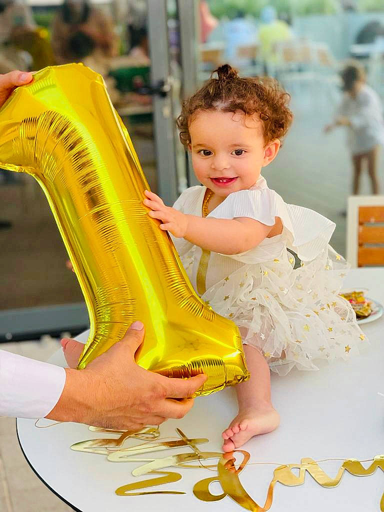 Aalia participe au concours pour gagner de l'argent avec cette photo : baby_toddler_clothing, chair, child, dress, event, fashion_design, flooring, foot, fun, happy, human_leg, joy, leisure, nail, peach, person, play, sandal, sitting, skin