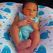 Tajari joined the competition — help win amazing prizes! baby, infant, pillow, whale_pattern, blue_blanket, clothing, face, hands, feet, indoors, person, cute, newborn, resting, young_child, soft_texture, sleeping_area, baby_garment, expression, tiny_fingers