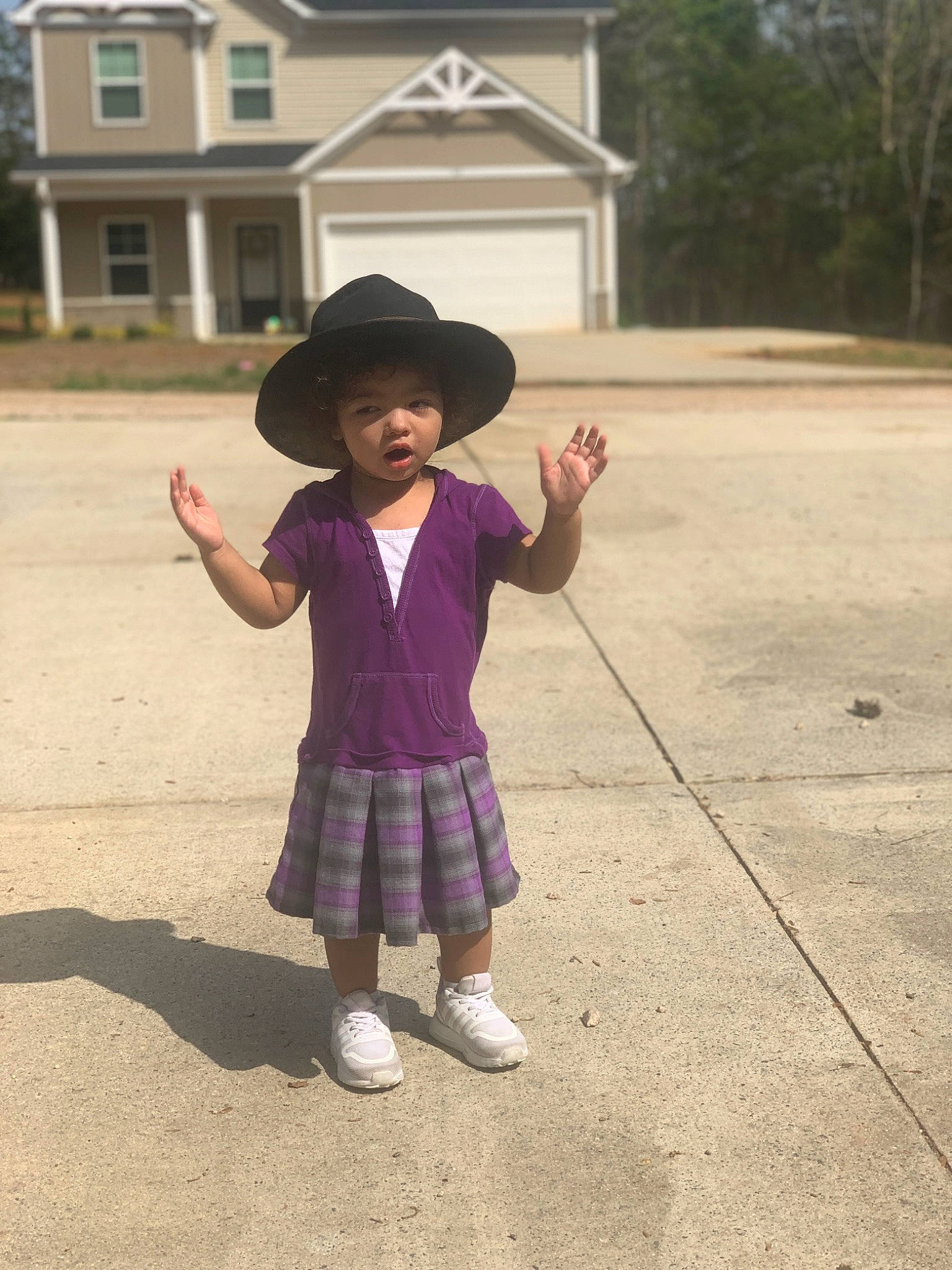 Milani is registered to the contest to win money with this photo: asphalt, child, fun, gesture, grass, happy, hat, headgear, magenta, pattern, person, pink, purple, road_surface, shoe, sleeve, standing, sun_hat, tints_and_shades, toddler