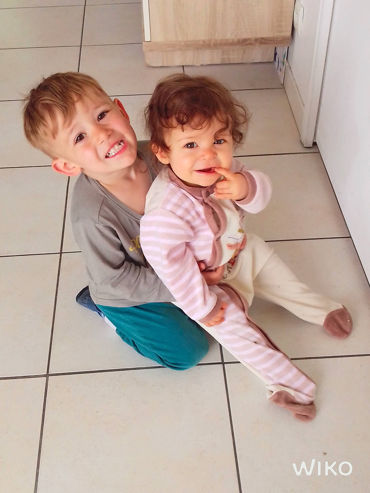 Léonie participe au concours pour gagner de l'argent avec cette photo : arm, baby, baby_toddler_clothing, cheek, child, flash_photography, floor, flooring, foot, gesture, happy, joint, joy, leg, mammal, person, shoulder, skin, sleeve, smile