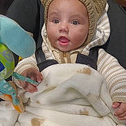 Theo joined the competition — help win amazing prizes! baby, infant, child, knitted_hat, bear_ears, blanket, soft_toy, car_seat, warm_clothing, striped_sweater, cute, curious, indoors, portrait, face, hands, expression, cozy, wrapped, seated