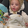 baby, infant, child, knitted_hat, bear_ears, blanket, soft_toy, car_seat, warm_clothing, striped_sweater, cute, curious, indoors, portrait, face, hands, expression, cozy, wrapped, seated