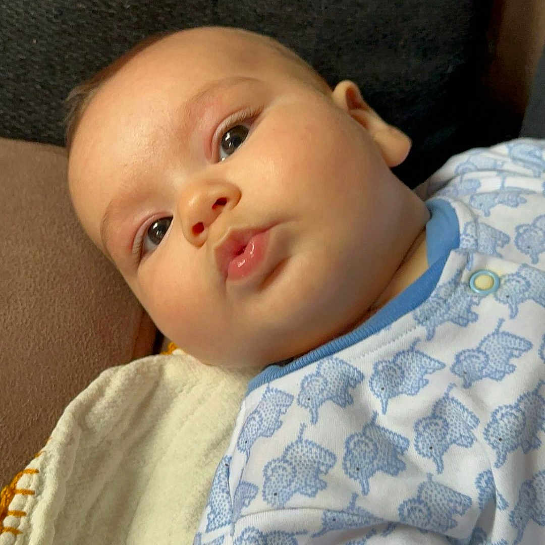 Noah is registered to the contest to win money with this photo: baby, bed, blanket, bodypart, clothing, couch, cushion, face, furniture, happy, head, homedecor, newborn, person, photography, portrait, quilt, sleeping, smile, t_shirt