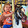 Kolton joined the competition — help win amazing prizes! child, toddler, carousel, horse, amusement_ride, golden_pole, curly_hair, smiling, orange_shirt, blue_shorts, carnival, lights, hand, fun, outdoor, playful, portrait, family, summer, happy