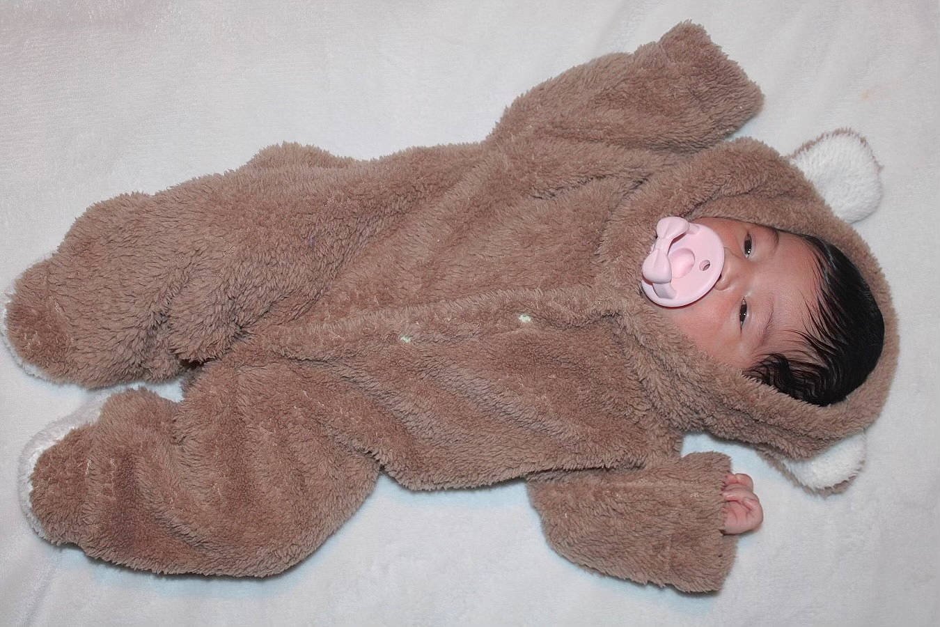 Ariana is registered to the contest to win money with this photo: art, baby, baby_toddler_clothing, beanie, cap, comfort, fashion_accessory, fur, grey, hat, headgear, knit_cap, knitting, linens, outerwear, pattern, person, sleeve, stuffed_toy, wool