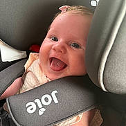 Gracie is registered to the contest to win money with this photo: baby, child, car_seat, smile, happy, infant, seat_belt, pink_bow, closeup, cute, person, safety, car_interior, joy, portrait, child_safety, infant_clothing, strapped, seat, head_support