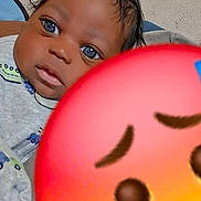 Zaire is registered to the contest to win money with this photo: baby, background, blue_eyes, child, closeup, clothing, crying_emoji, cute, emoji, expression, face, hair, head, indoor, infant, person, portrait, skin, sleeve, young_child