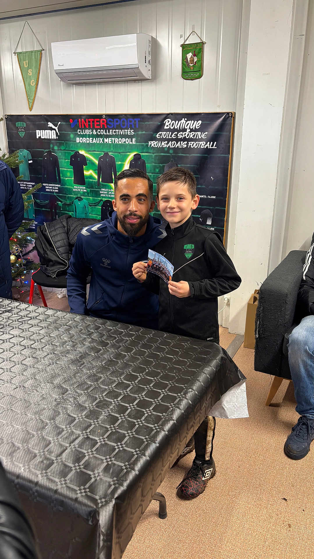 Tiago a rejoint le concours — aidez-le/la à gagner de superbes lots ! child, man, sportswear, indoor, banner, table, chair, smile, photo, advertisement, air_conditioner, carpet, christmas_tree, black_jacket, sports_event, person, footwear, wall, celebration, pose