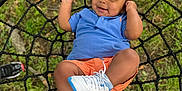 Traesyn is registered to the contest to win money with this photo: baby, blue_shirt, casual, child, cute, feet, footwear, grass, happy, leisure, net_swing, orange_cap, orange_shorts, outdoor, person, play, smiling, summer, swing, white_sneakers