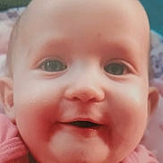 Nounouille participe au concours pour gagner de l'argent avec cette photo : baby, close_up, smiling, face, child, pink_clothing, chubby_cheeks, eyes, head, skin, portrait, infant, cute, happy, young_child, person, baby_girl, indoors, warm_tones, soft_background